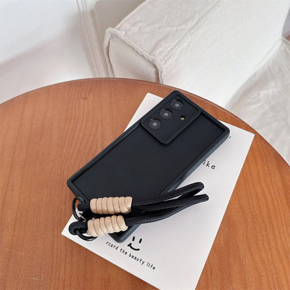 Black phone case with a lanyard on a wooden surface